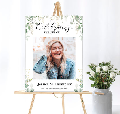 A beautiful funeral poster sits on an easel next to some flowers. It has a leafy green background with a large center photo of your loved one.
